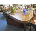 A teak extending dining table with six standard dining chairs and two carvers, each with loose