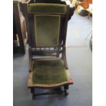 An early 20th century walnut American rocker chair upholstered seat and back in a green fabric,