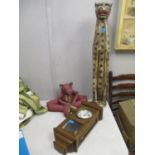 A tall painted and carved wooden, floor standing model of a seated cheetah, with a wooden cased wall