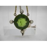 A late 19th/early 20th century pendant set with a round cut peridot and four seed pearls in a yellow