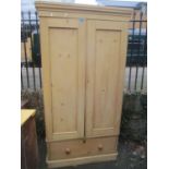 A Victorian pine two door wardrobe with single drawer below and on a plinth base 199cm h x 96cm w