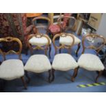 A matched set of six Victorian balloon back chairs with pierced centre rails, overstuffed seats