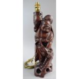 A Carved Chinese Hardwood Figural Table Lamp Stand in the Form of Smiling Immortal, 43cm High
