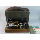 A Cased Singer Sewing Machine, with Instruction Books and Accessories
