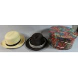 A Modern Floral Cylindrical Hat Box Containing Three Panama Hats
