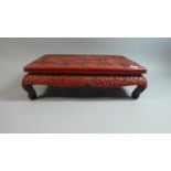 A Reproduction Cinnabar Lacquer Rectangular Low Stand or Table on Scrolled Feet, The Top Decorated