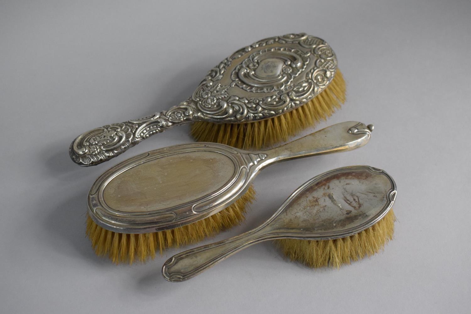 A Collection of Three Silver Mounted Dressing Table Hair Brushes, Birmingham and London Hallmarks