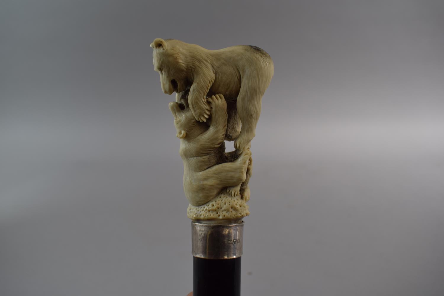 A Gents Ebonised Thornwood Walking Cane with Carved Antler Finial Depicting Two Bears Fighting