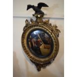 A Regency Gilt Gesso Circular Convex Wall Mirror with Eagle Mount having Associated Balls and Chain.