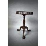 A Reproduction Circular Mahogany Tripod Table with Spindle Gallery and CLaw and Ball Feet. 46cms