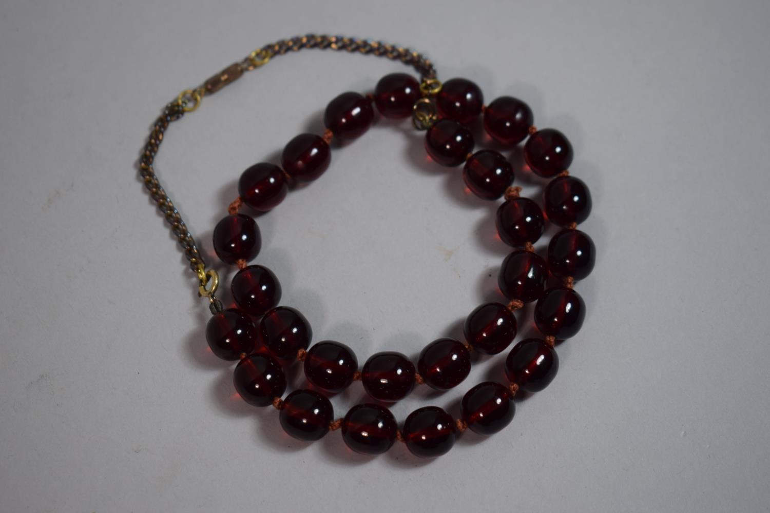 A Bakelite String of Cherry Amber Style Beads. Each Approx 1cm Long.