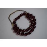 A Bakelite String of Cherry Amber Style Beads. Each Approx 1cm Long.