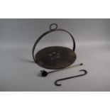A Circular Iron Skillet with Hoop Handle and Iron 'S' Hook Together with Reproduction Candle Snuffer
