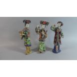 A Set of Three Oriental Glazed Figures of Maidens with Bird, Posy and Basket of Flowers. Seal Marks.