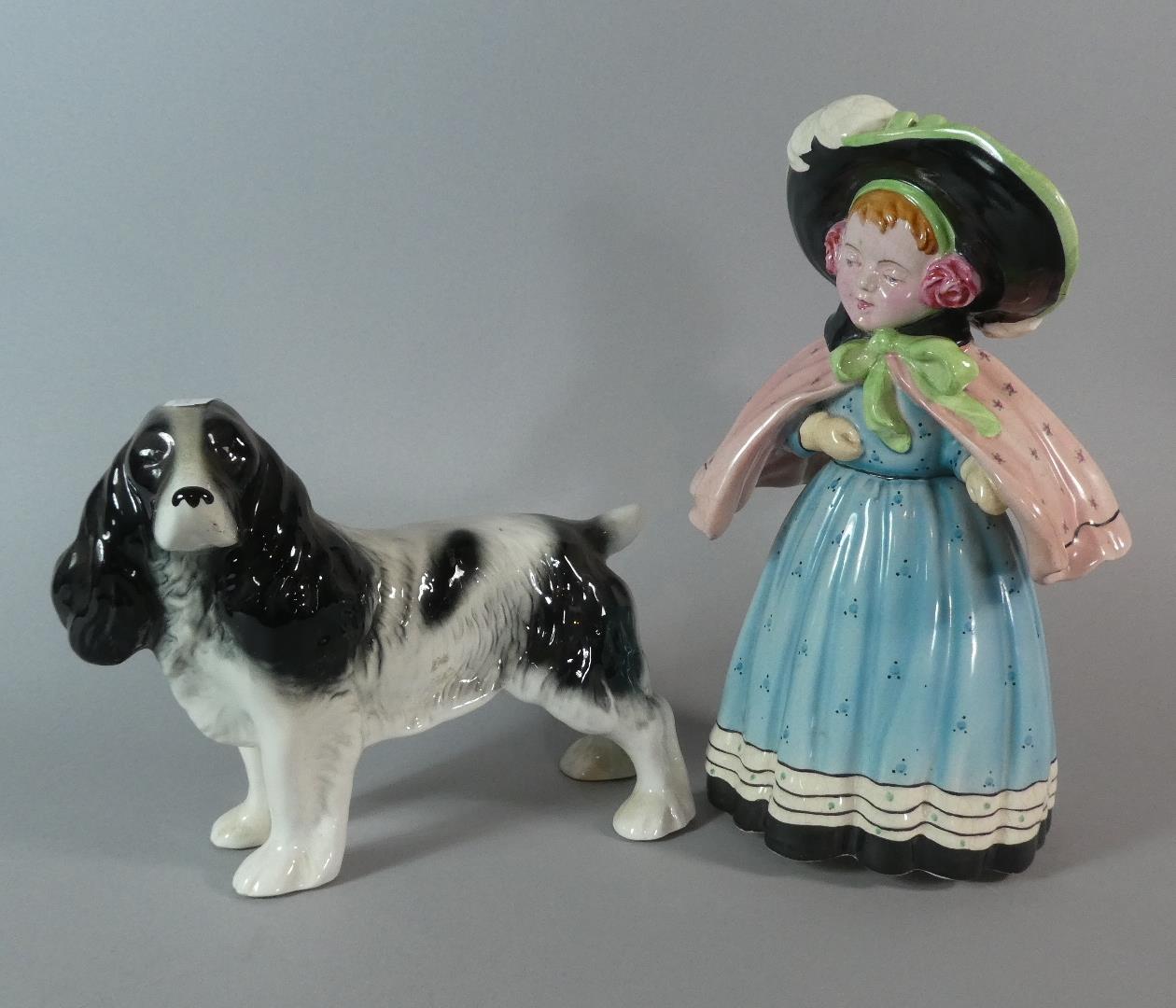 A Fieldings Devon Ware Figure of Girl with Cape and Bonnet Together with a Melbaware Spaniel