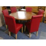 A Circular Extending Table and Six Red Leather Effect Dining Chairs