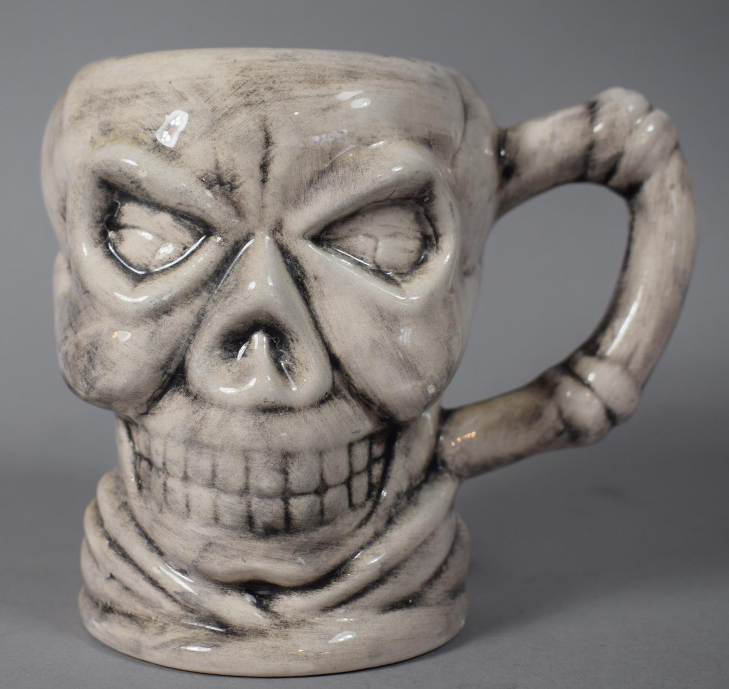 A Novelty Mug in the Form of a Skull, 12cm High