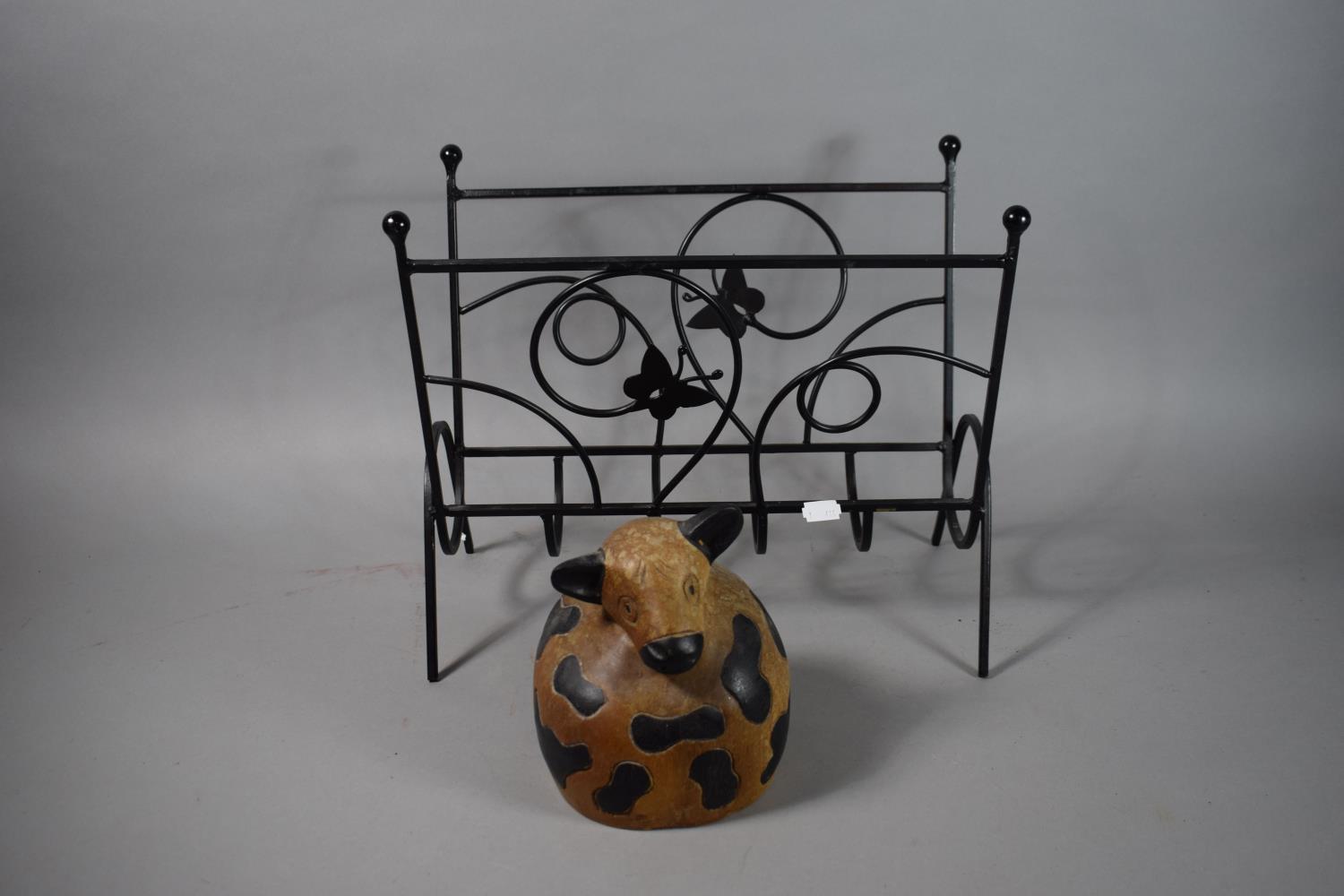 A Carved Wooden Door Stop in the Form of a Seated Cow,17cm high, and a Modern Wrought Iron