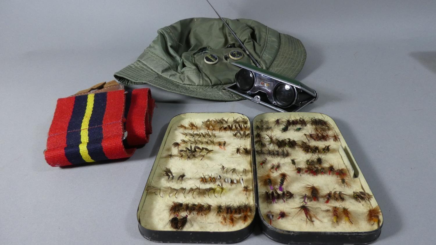 A Vintage Tin of Fishing Flies, a Hat with inbuilt Radio, a Pair of Folding Binoculars and a