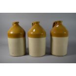 A Set of Three Honey Glazed Stoneware Bottles Stamped "Civil Service Stores Wine Dept"