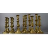 A Collection of Six Pairs of Brass Candle Sticks