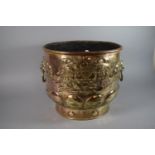 A Large Brass Coal Bucket with Relief Armorial Crest and Two Lion Mask Ring Carrying Handles.