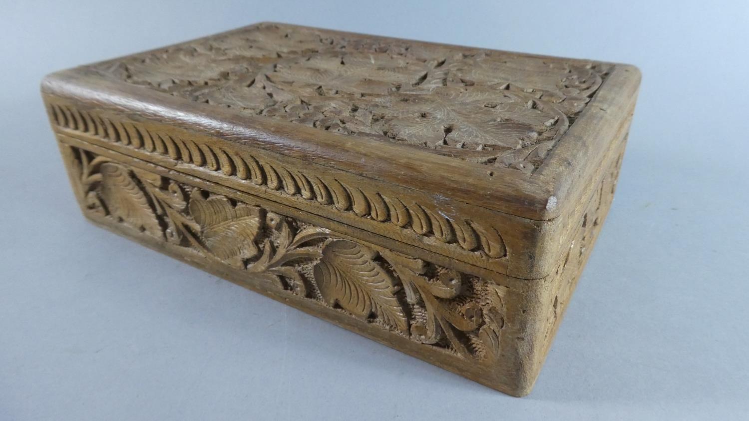 A Carved Wooden Box with Vine Leaf Decoration, 22.5cms Wide