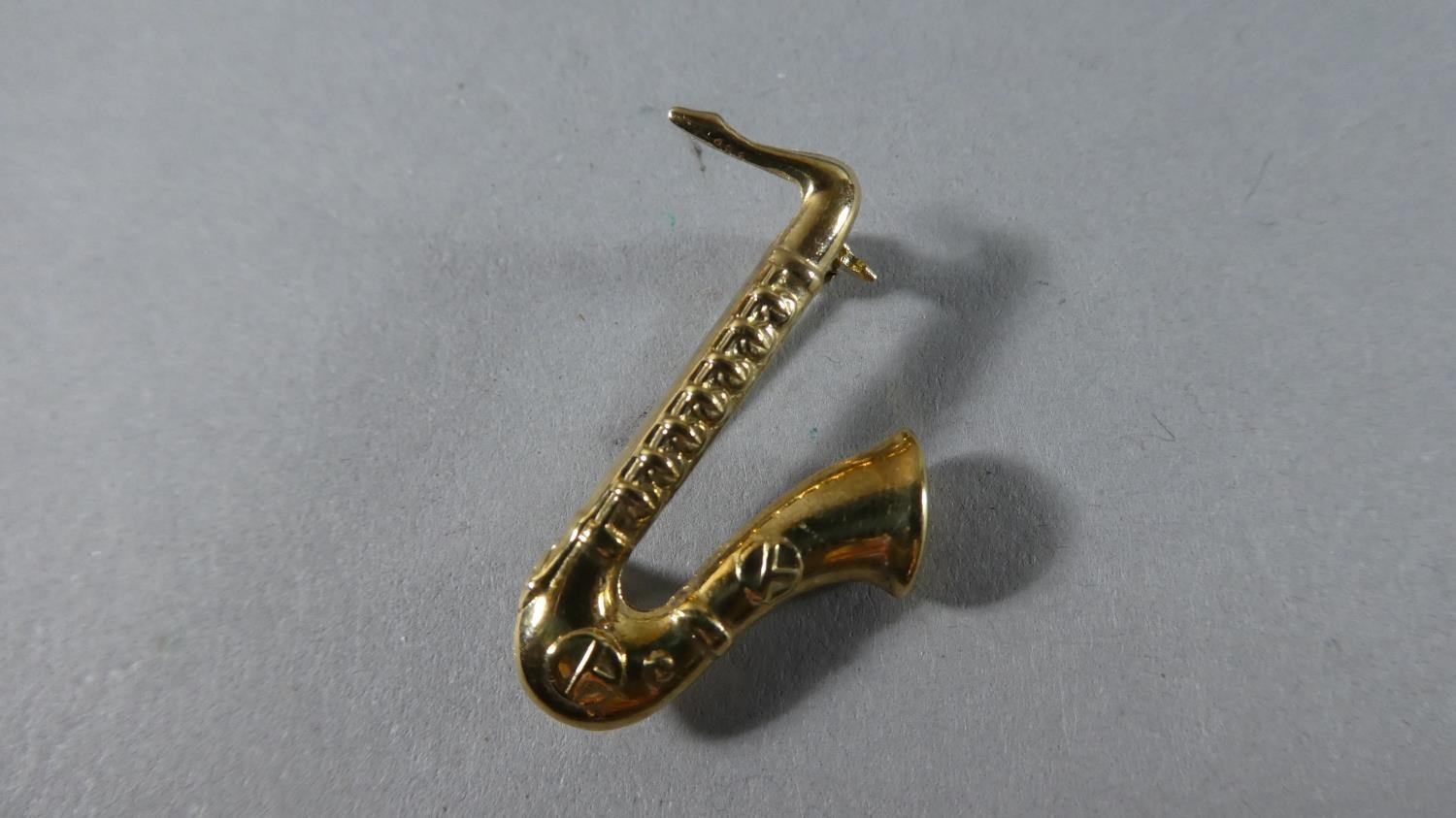 A 9 Carat Gold Novelty Brooch in the Form of a Saxophone, 1.9gms