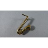 A 9 Carat Gold Novelty Brooch in the Form of a Saxophone, 1.9gms