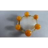 An Oriental Amber and Mother of Pearl Circular Brooch, with Engraved Pagoda Decoration, 3cms Diam