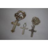 A Collection of Three Silver Crucifixes, Two on Chains and One Example by Charles Horner