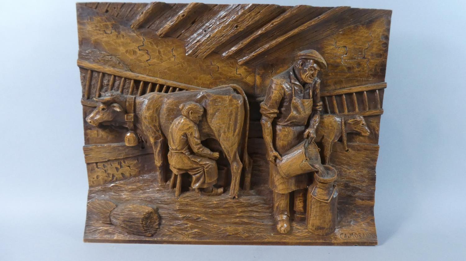 A Cast Resin Copy of a Carved Black Forest Style Wall Hanging Depicting Farmer and Wife Milking