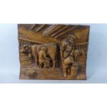 A Cast Resin Copy of a Carved Black Forest Style Wall Hanging Depicting Farmer and Wife Milking