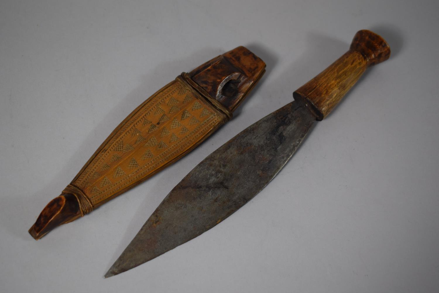 A Tribal Dagger with Wooden Handle, Leaf Blade and Carved Wooden Scabbard, Blade 20.5cms Long