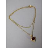 A Gold Heart Shaped Pendant with Inset Ruby and Five Chip Diamonds on Yellow metal Chain