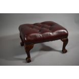 A Modern Red Leather Button Upholstered Stool on Short Cabriole Legs Culminating in Claw and Ball