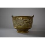 A Bronze Chinese Bowl with Swing Handle, the Body Decorated with Dragons and Scrolls in Relief,