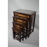 A Nest of Four Oriental Tables with Deeply Carved Top Panels Under Glass, 51cms Wide