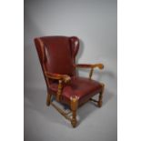 A Leather Upholstered Oak Framed Scroll Arm Wing Armchair