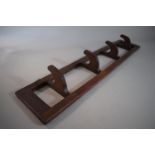 An Edwardian Mahogany Wall Hanging Coat Rack with Four Hinged Hooks, 67.5cms Wide