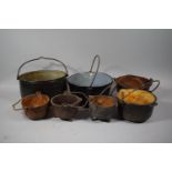 A Collection of Seven Cast Iron and Enamelled Pans Each with Iron Loop Handles, Largest 38cms