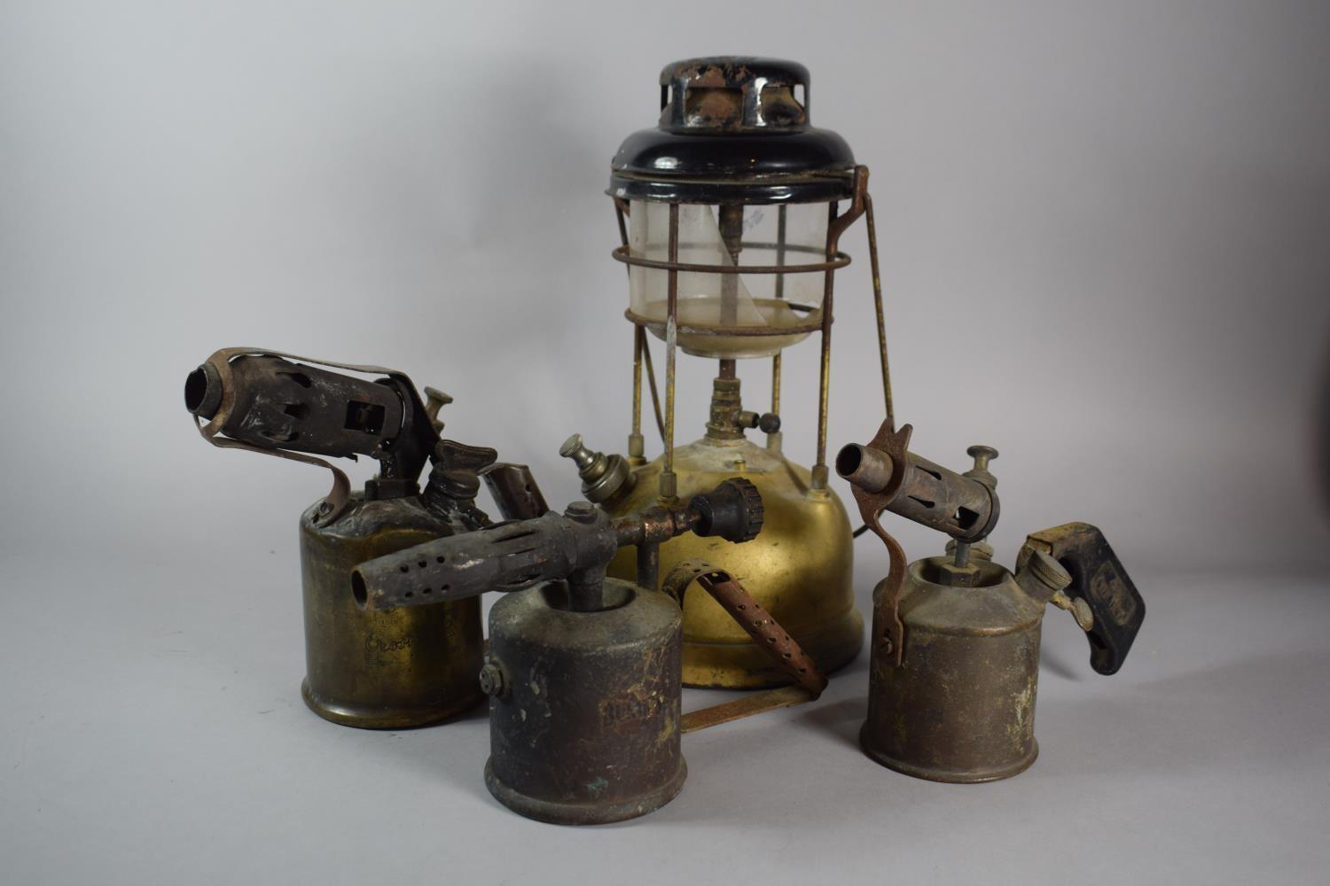 A Vintage Hurricane Lamp and Three Blow Torches