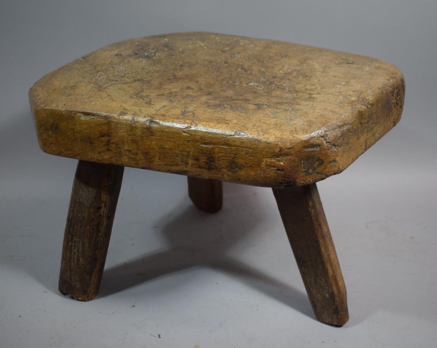 An Early 19th Century Heavy Elm Topped Three Legged Pig Bench Stool, 55cms Long