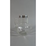 A Small Silver Rimmed Glass Water Jug, 10cms High