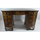 A Serpentine Fronted Walnut Kneehole Writing Desk with Tooled Leather Top, Centre Drawer and Two