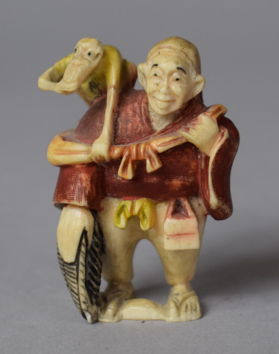 An Early 20th Century Japanese Carved Netsuke in the Form of a Trader with Monkey on Shoulder