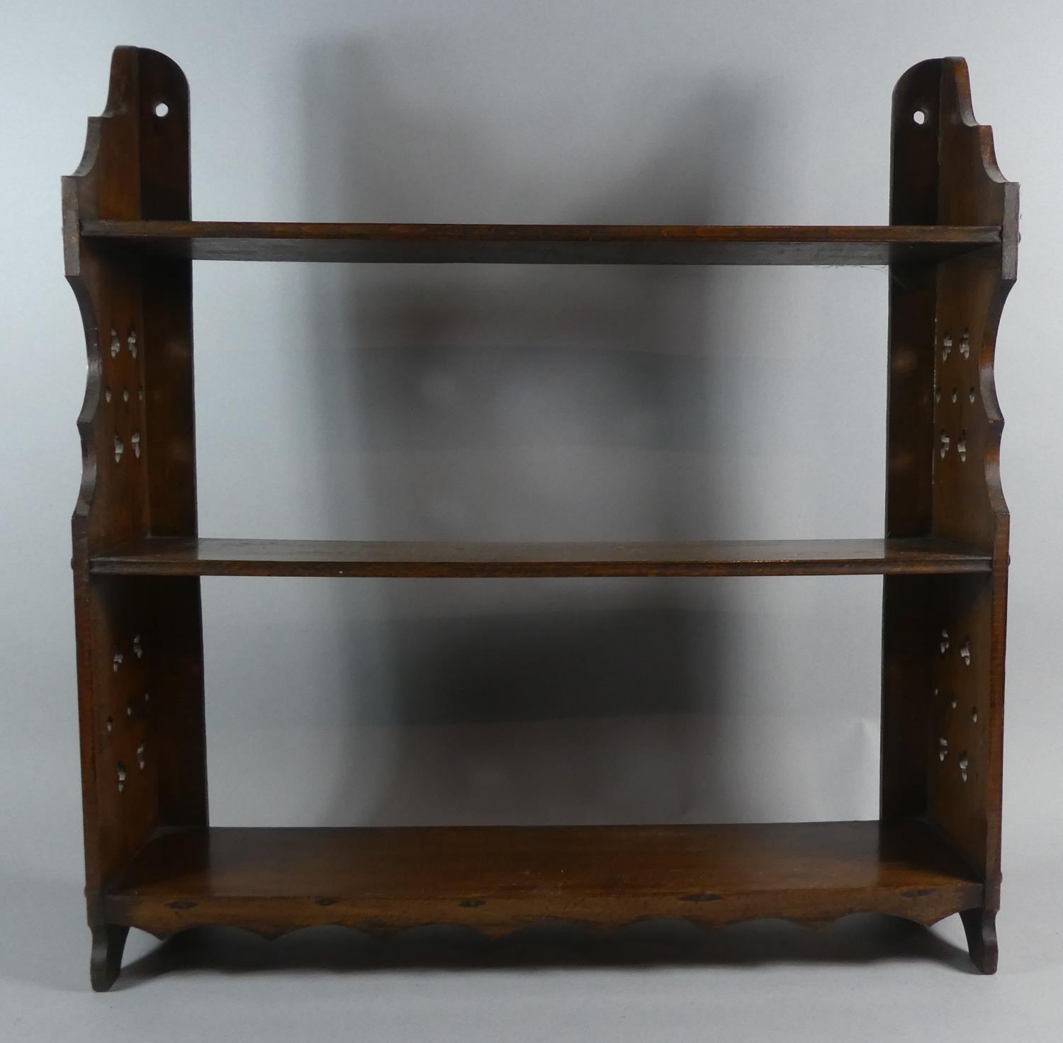 An Edwardian Mahogany Three Tier Wall Mounting Shelf with Pierced Supports, 57cm Wide