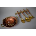A Collection of Four Graduated Copper Pans and Set of Brass Servers on Wall Hanging Rack