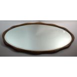 An Edwardian Oak Framed Bevelled Edge Oval Wall Mirror, 71cm wide