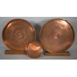 Two Large Copper Circular Plaques with Stands and a Smaller Copper Tray, Largest 69cm Diameter